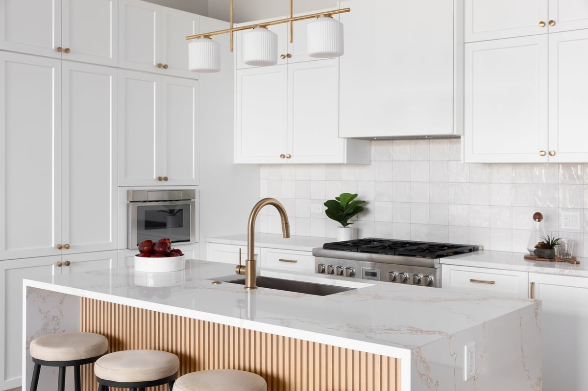 Luxury marble kitchen with waterfall countertop and brass fixtures