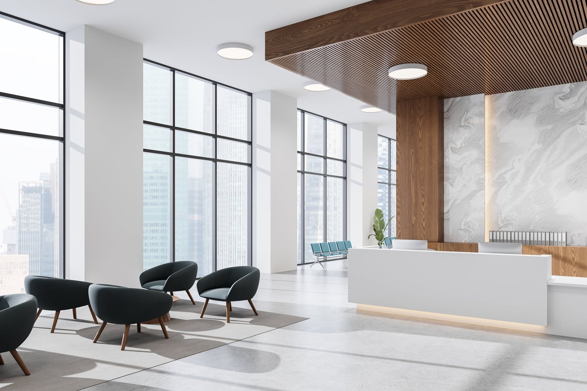 Modern office lobby with marble reception desk and polished stone flooring